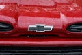 The front emblem of a full-size pickup truck Chevrolet Apache C20 in drops of rain, close-up