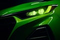 Front end of a green sports car illuminated by its bright headlights, AI-generated. Royalty Free Stock Photo