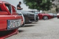 Front end and license plate of an Alfa Romeo 155, parked in a row with multiple other Alfa Romeos, part of an exhibition