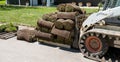 Front end loader and a pallet with rolls of sod grass for installation Royalty Free Stock Photo