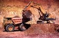 Front end loaders and dump trucks moving ore