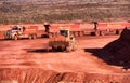 Front end loaders and dump trucks moving ore