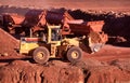 Front end loaders and dump trucks moving ore