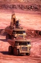 Front end loaders and dump trucks moving ore