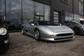 The front end of a silver Jaguar XJ220.