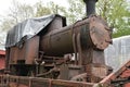 Front-end view on discarded rusty freight steam locomotive loaded on old wagon. Royalty Free Stock Photo