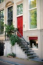 Front entrance door with large windows. Red vintage door with a staircase Royalty Free Stock Photo