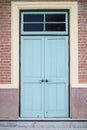 A front entrance of a museum with a blue door and red brick siding Royalty Free Stock Photo