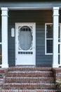 Front exterior door of a small blue gray mobile home with red brick steps Royalty Free Stock Photo