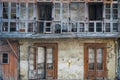 Front facade with windows and a closed terrace of an old and abandoned house. Royalty Free Stock Photo