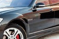 The front of the fender of a black car with wheels and a side rear-view mirror of a representative business class of the Mercedes- Royalty Free Stock Photo