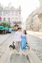 Front full length view of attractive young couple walking with their husky dog on the city street. Pretty girl in blue Royalty Free Stock Photo