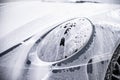 Front of a gray sports car and the front light are covered with active foam