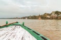 Front of the green boat floating on the Ganga River is heading to pray at The holy Dasaswamedh Ghat, near Kashi Vishwanath Temple