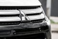 The front grill of Mitsubishi Outlander vehicle with a badge and parking sensors Royalty Free Stock Photo