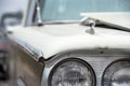 Front headlight of classic 1960s atutomobile ourside in sunshine Royalty Free Stock Photo