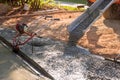In front of home mixer truck pours wet cement ready mixed concrete for a driveway Royalty Free Stock Photo