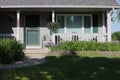 Front of house, porch and flower gardens with purple Irises, Purple Pansies and a hanging basket Royalty Free Stock Photo