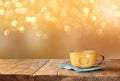 Front image of coffee cup over wooden table and autumn leaves in front of forest background . retro style image Royalty Free Stock Photo