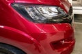 Front intermittent headlight of modern new red van parked in dealership Royalty Free Stock Photo