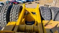 front of a large mining machine, you can see the detail of the cars parked in front