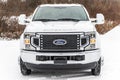 the front of a large white ford f250 truck parked in the snow Royalty Free Stock Photo