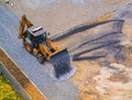 Front loader poured gravel from the ladle at the construction site of the school stadium Royalty Free Stock Photo