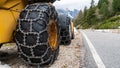 Front loader for snow removal with metal snow chains on wheels. Snow removal in the mountains. Royalty Free Stock Photo