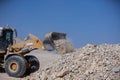 Front loaders disposing rocks in quarry area