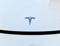 Front logo of a white Tesla Model 3