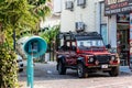 Front look of Land Rover Defender prepared for off-road driving, stands near tourism agency