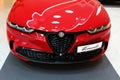 Front mask of first hybrid-powered italian compact crossover SUV car Alfa Romeo Tonale in red colour