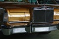 Front mask of golden metallic coloured full-size american luxury classical car Lincoln Continental Mark VI