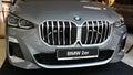 Front mask of modern subcompact executive car BMW 2er, possibly U06 in dark silver metallic colour, displayed on motorshow.