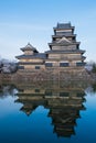 Front Matsumoto castle water reflection in sunset time , the castle is famous premier historic castles in spring season with sakur Royalty Free Stock Photo