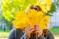 Front middle angle view of unrecognizable woman holding maple tree leaves.view of woman with fallen maple leaves in warm Royalty Free Stock Photo