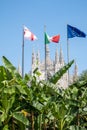 In front of Milan Cathedral the Italian, English and European flags are flying