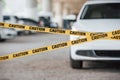Front of modern luxury vehicle. Yellow caution tape near the car parking lot at daytime. Crime scene Royalty Free Stock Photo