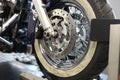 Front motorcycle wheel with shiny brake disc closeup