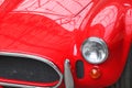 Front of old red car close up with round headlight Royalty Free Stock Photo