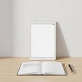 In front of it, an open notebook displays handwritten text on lined pages Royalty Free Stock Photo