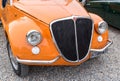 The front of the Orange Classic Vintage Italian Fiat, parked in the historic center of Varese, Italy