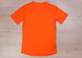 Front orange running tshirt on wooden background