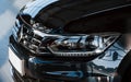 Front part of brand new modern car. Parked at showroom. Reflection in the headlights Royalty Free Stock Photo