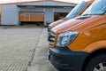 Front part of a row of two orange delivery vans in front of logi Royalty Free Stock Photo