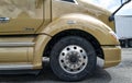 The front passenger side wheel on a tan T680 Kenworth semi truck parked in a rest stop on Interstate 90 in Washington, USA Royalty Free Stock Photo