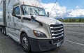 The front passenger side of a white Freightliner Cascadia semi truck parked in a rest stop on Interstate 90 in Washington, USA Royalty Free Stock Photo