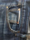 Front pocket of blue frayed jeans.