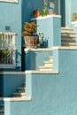 Front porch stairs with blue and white accented hand rails and decorative yard potted plants and trinkets near door Royalty Free Stock Photo