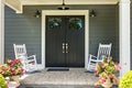 A front porch with two rocking chairs, stamped concrete floors, and double glass doors Royalty Free Stock Photo